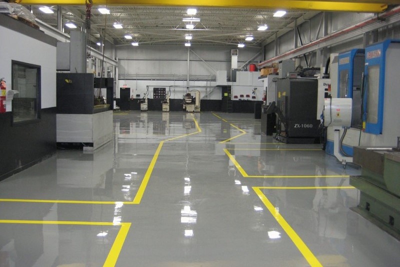 Commercial epoxy flooring is ideal for a wide variety of commercial and industrial applications. Commercial and industrial epoxy floor coatings are strong, durable finishes for concrete. They transform a regular concrete floor that is absorbent and vulnerable into one that repels chemicals and resists damage. There are many benefits to epoxy flooring in commercial settings which are quite remarkable. The final appearance is one area in which commercial epoxy flooring excels. Epoxy is extremely versatile for enhancing the aesthetics of any business, from retail and restaurants to garages and warehouses. Epoxy application can be tricky, and roller marks, bubbles, and pinholes are nearly inevitable when applied by someone without experience. Epoxy flooring installed by Elite Epoxy Floors in Jackson County, MO can be made to look like real marble, a single solid color, a speckled mix of colors, or even granite tiles. One of the most important factors when choosing flooring for any type of business is its durability and strength, and in this area, commercial epoxy flooring excels above the rest. Epoxy is a resin product that stands up to heavy objects being placed (or dropped) on the floor. It is shatter- and impact-resistant and it can last for decades if it is taken care of correctly. Instead of having to replace the flooring a few years down the road, it lasts for many years and won’t cause you unnecessary downtime at your business. The application process of commercial epoxy flooring contributes greatly to its durability and longevity. Professionals use either a diamond grinder or a shot blaster to mechanically clean and abrade the floor to prepare it, ensuring that the epoxy will adhere properly to the concrete and not peel over time.  A high-quality resin is combined with several other resins to make commercial epoxy flooring. This produces a cross-linking system which makes the epoxy floor coating flexible. It doesn’t peel, chip, dent, or crack when applied properly. The coating used by professionals is generally a 2:1 mix of epoxy and a hardener. Both parts are 100% solids, meaning that the product does not contain water. Epoxy coatings that do not contain water are much harder than epoxy paints and bond better with concrete. To learn more about commercial epoxy flooring, call Elite Epoxy Floors at (816) 729-7143, or click here to request a free estimate.